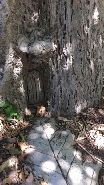 A faerie door sculpted into in a faux bois tree.