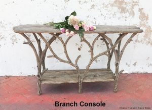 Faux bois branch console table, white wall, flowers